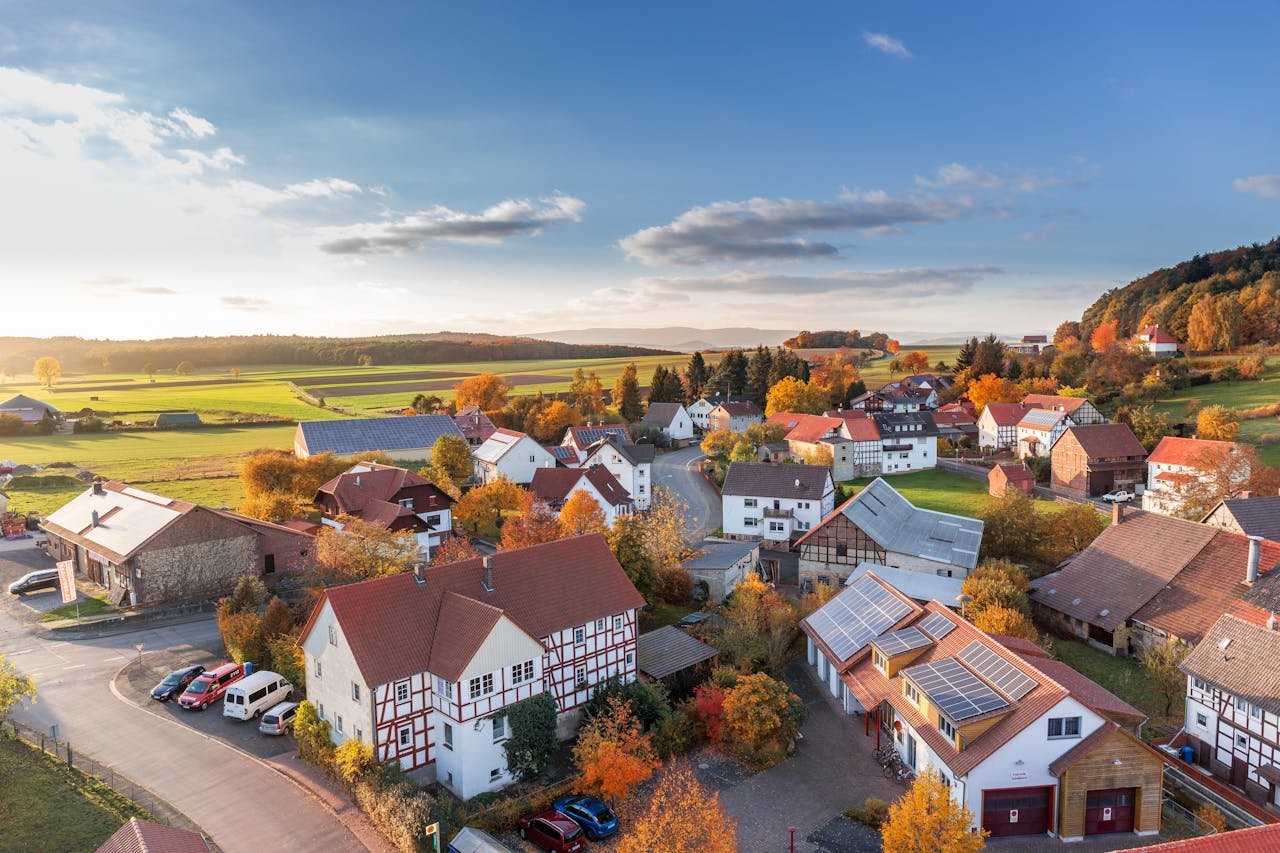 gallery-4 Charming aerial view of a rural village in autumn with vivid colors and clear skies.