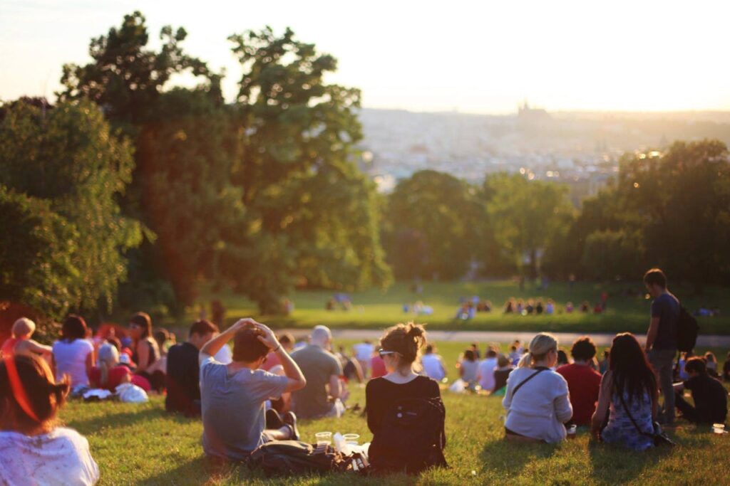 Quand Dieu semble absent People relaxing and enjoying a sunny day in a bustling city park.
