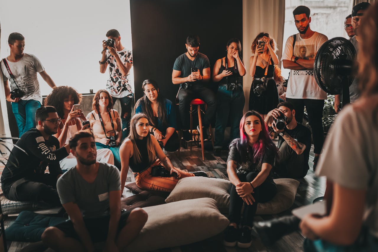 gallery-2 Group of multiethnic young people wearing casual clothes gathering together in spacious studio and listening attentively to female speaker